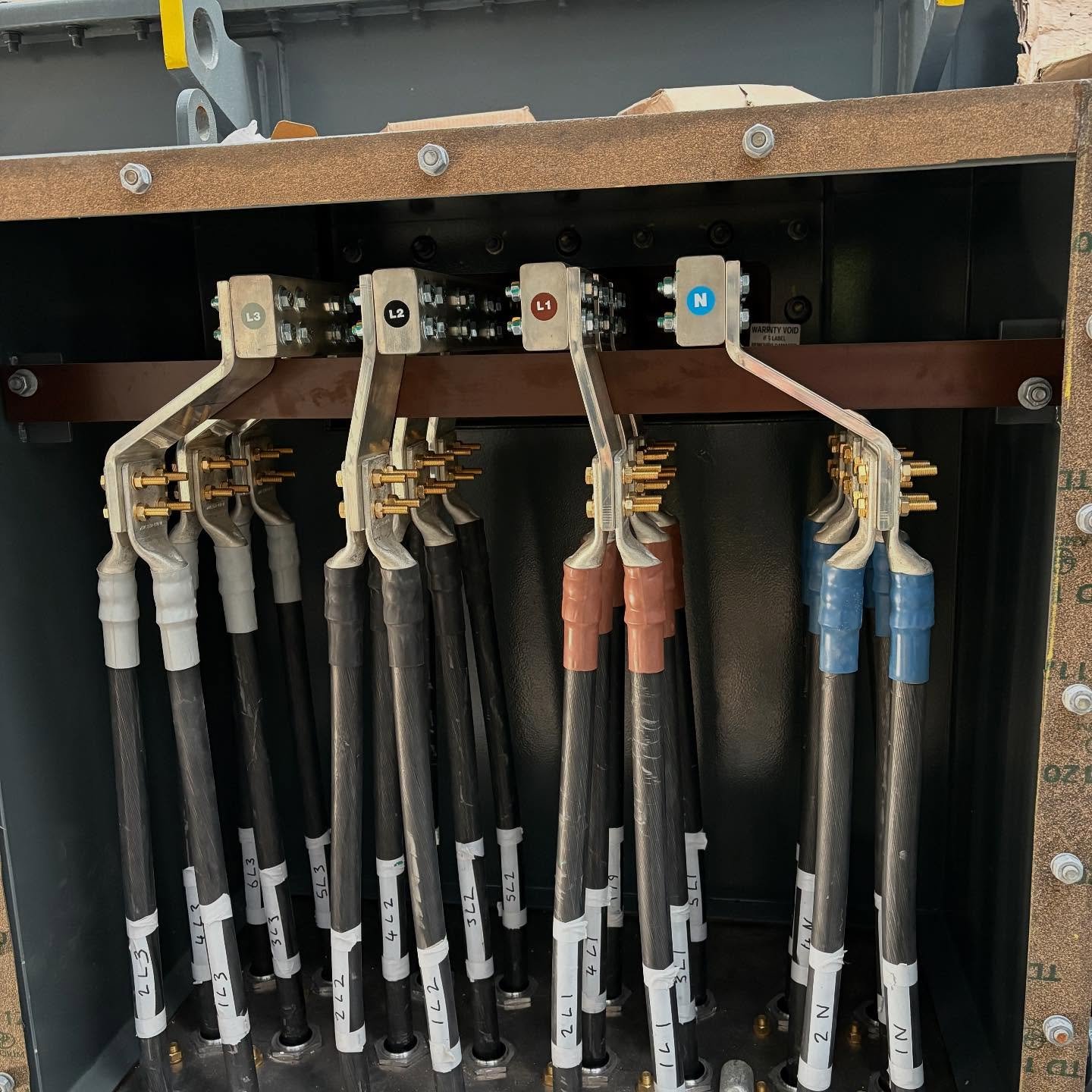 Steel cable tray system running along warehouse ceiling with SWA cables and conduit