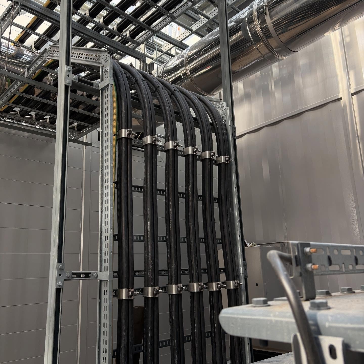 Overhead cable tray in commercial warehouse showing cable routing and support brackets