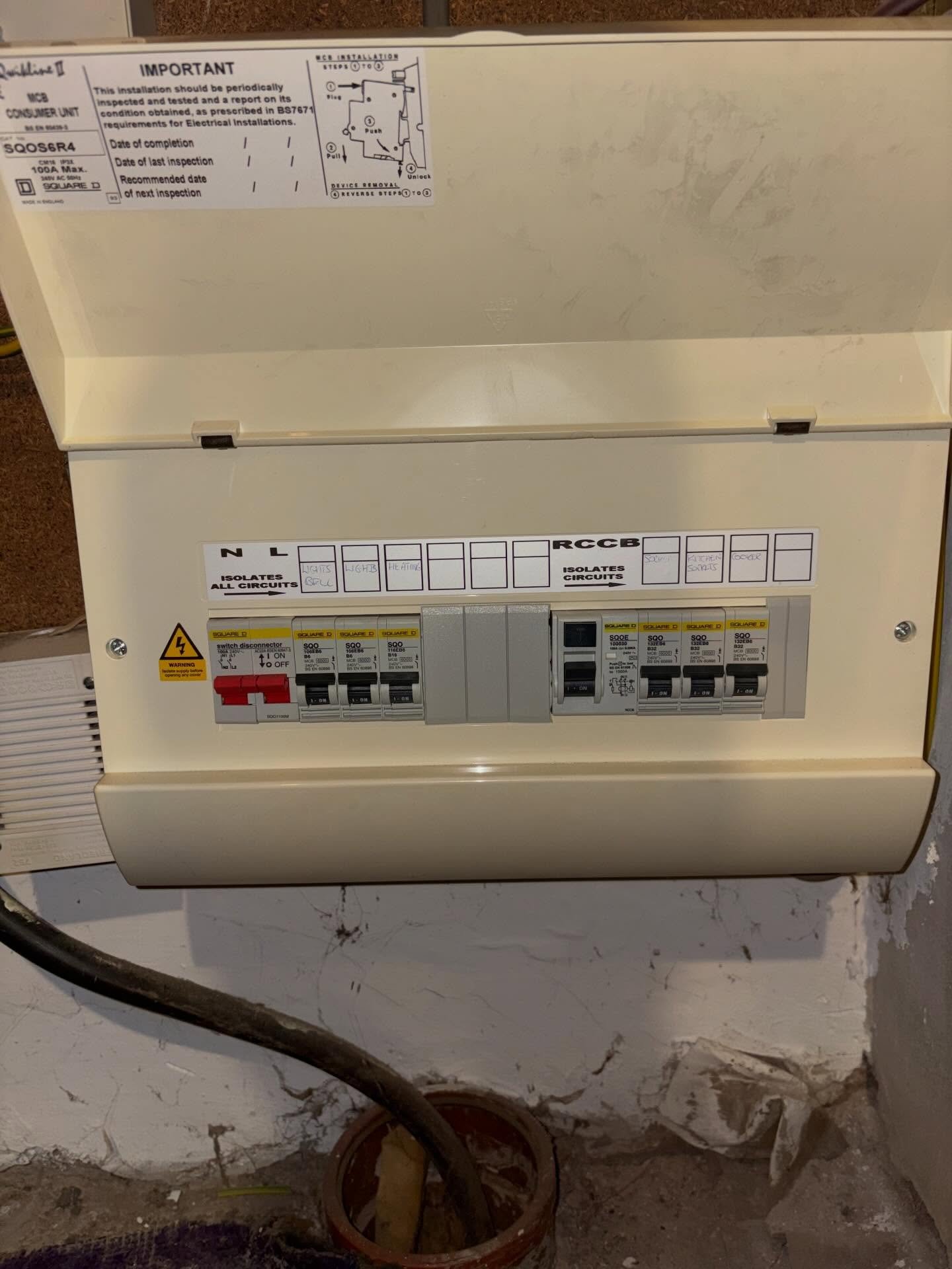 Severely burnt and fire-damaged consumer unit interior showing heat damage to MCBs