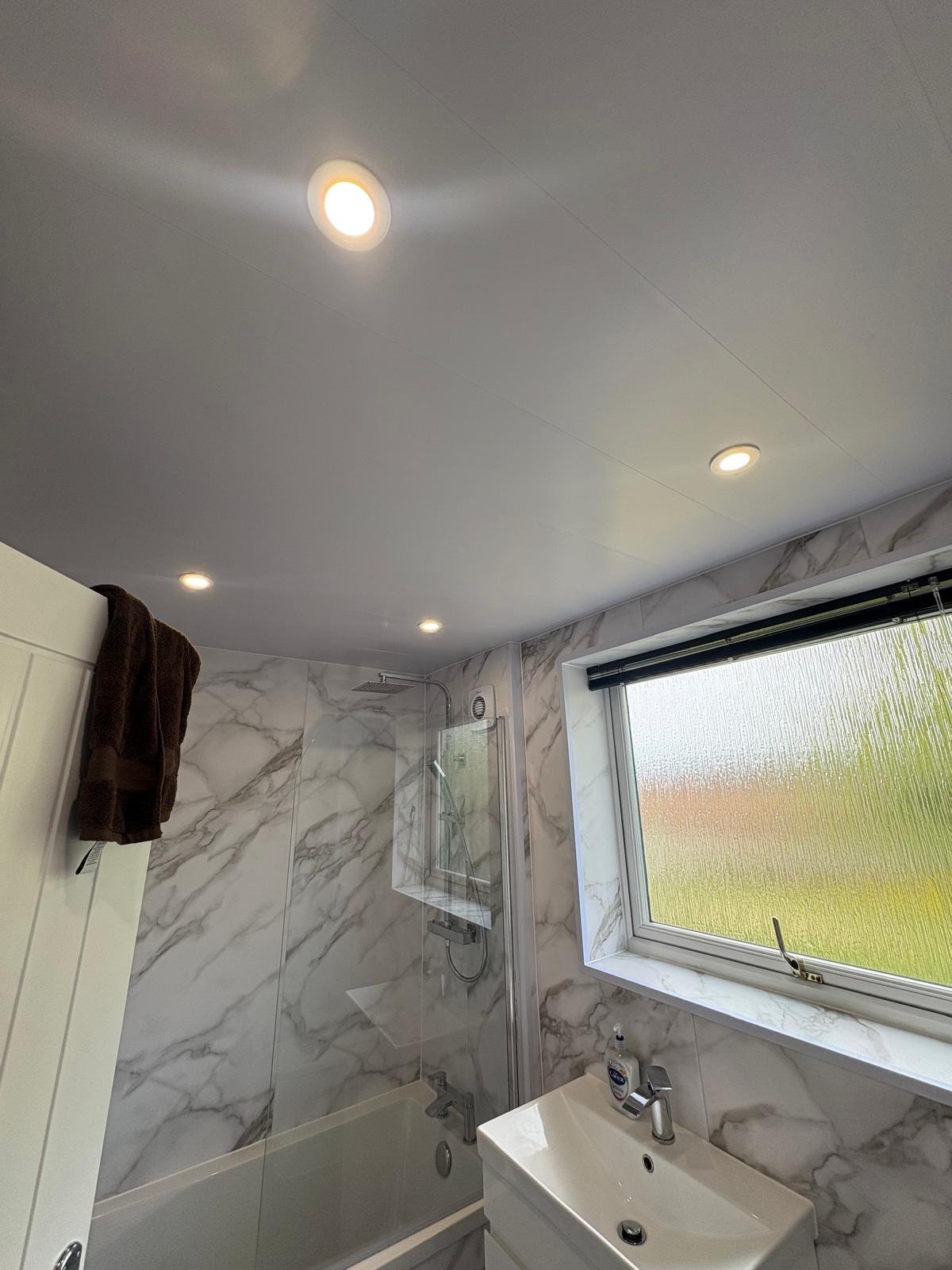 Bathroom with IP-rated recessed LED downlights over bath and shower zone