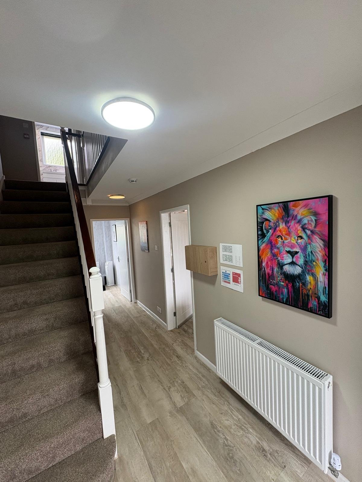 Hallway and staircase with flush LED ceiling lights and boxed-in consumer unit