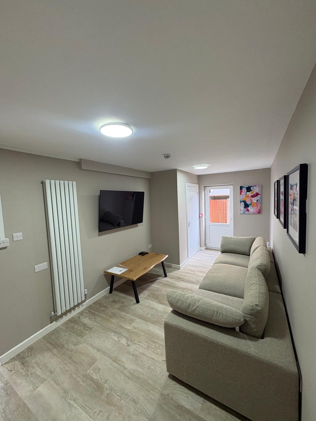 Lounge with flush LED ceiling light, wall-mounted TV point and mains-linked smoke alarm