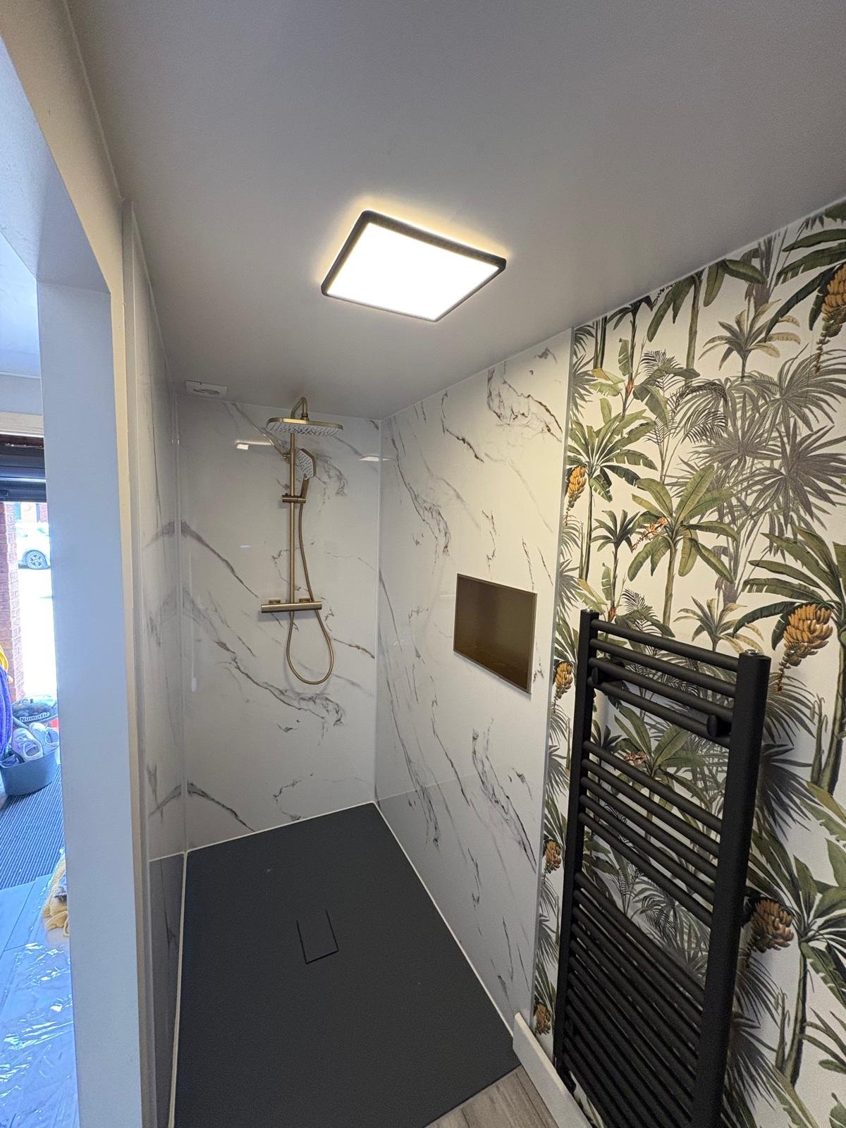 Walk-in wet room with flush LED ceiling panel and heated towel rail